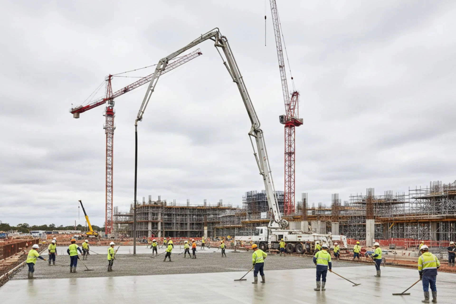 Concrete boom pump pouring a house slab on a residential construction site in Canberra with professional crew